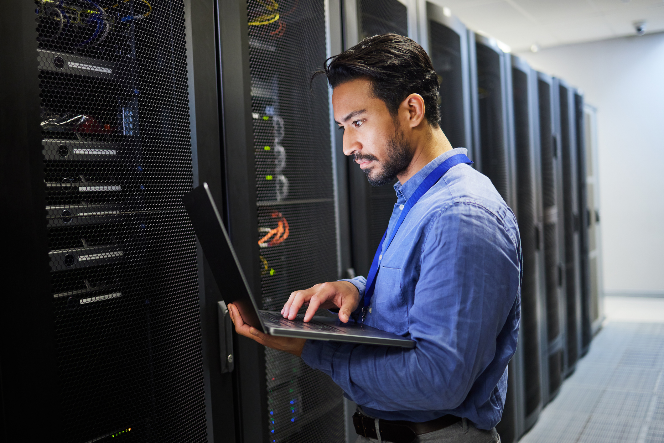 A professional with a laptop doing work on a network server.