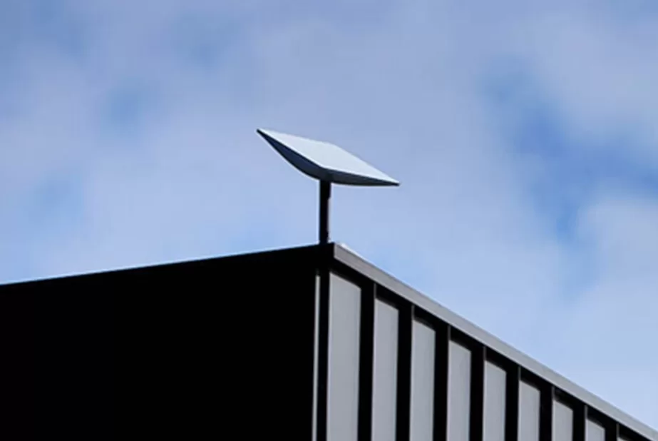 Technician installed a flat Starlink high-performance dish on a rooftop, representing best practices for fixed and mobile Starlink deployments.