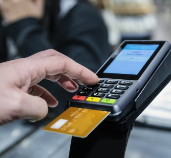 A credit card reader on a countertop, designed for secure transactions with a card slot and digital display.