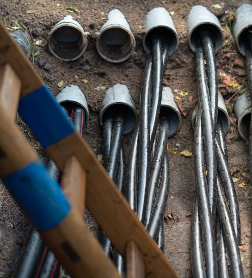 Close-up of electrical conduit installation with neatly arranged pipes, showcasing wiring pathways in a construction setting.