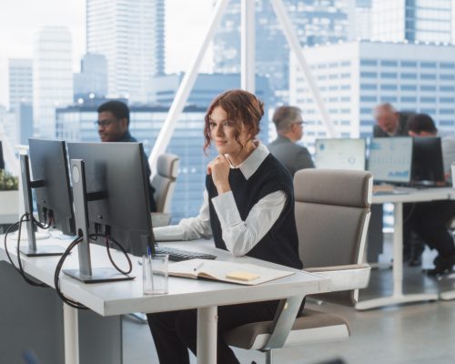 A professional using a computer at a desk, engaging with technology and digital tools in a modern workspace.