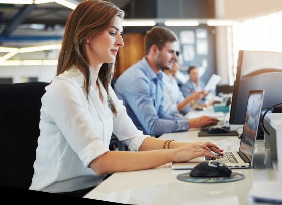 A diverse group of professionals collaborating in an office setting, discussing ideas and working together on projects.